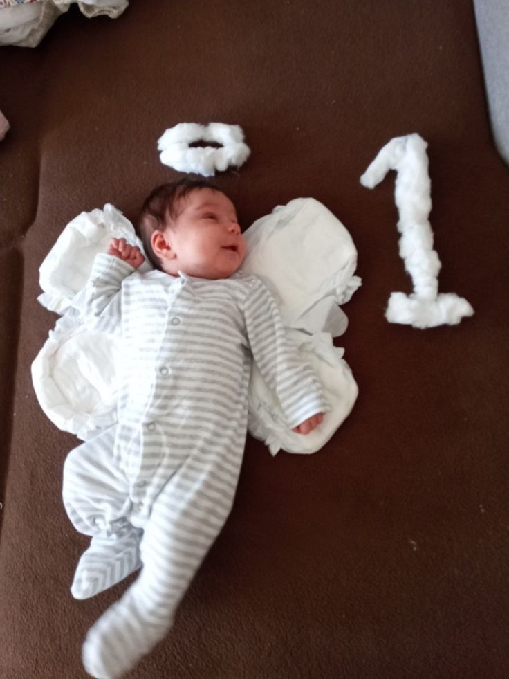 a baby is laying on the floor next to some toilet paper numbers and it looks like he has fallen asleep