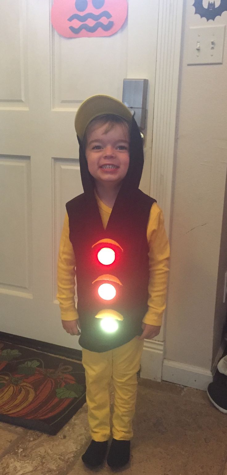 a little boy that is standing in front of a door wearing a light up costume