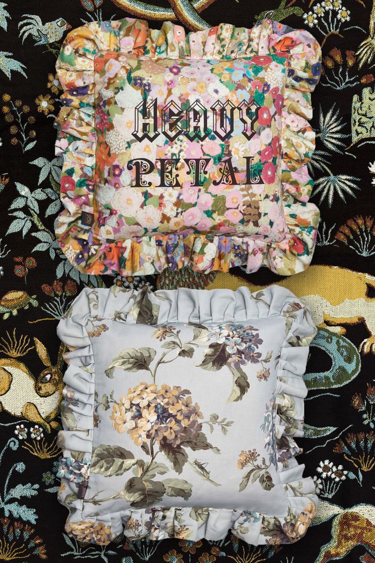 three pillows with the words happy petal printed on them, and one pillow with flowers