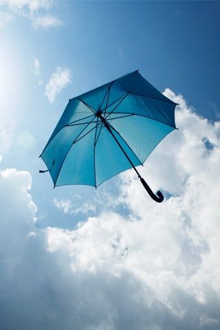 an open umbrella flying in the sky on a sunny day