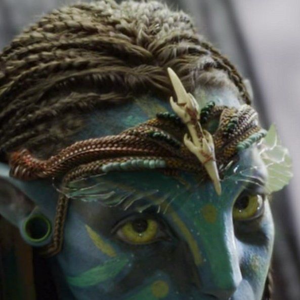 a close up of a person with blue makeup and dreadlocks on their head