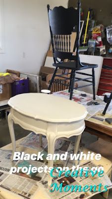 a white table and chair sitting on top of a pile of newspapers