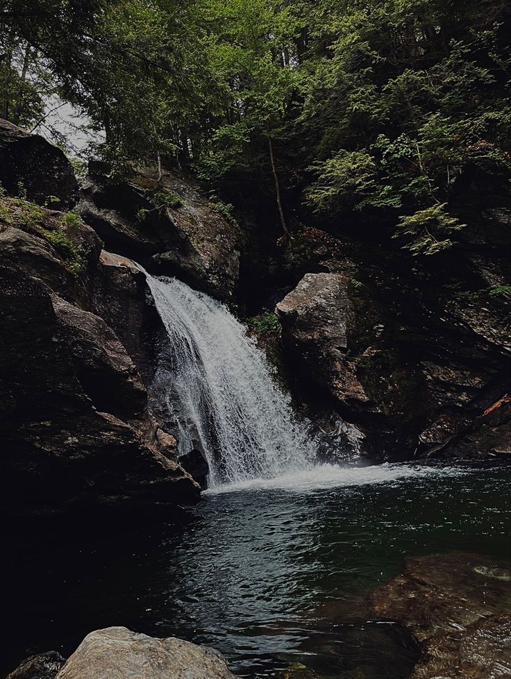 there is a waterfall in the middle of some rocks