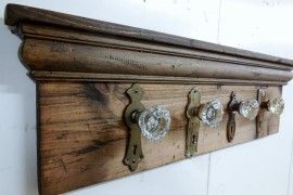 a wooden coat rack with four knobs on the front and two hooks on the back