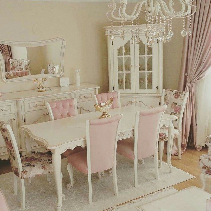 a white dining room table with pink chairs