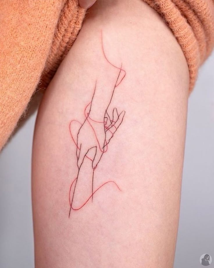 a woman's arm with a tattoo on it that has a red line in the middle