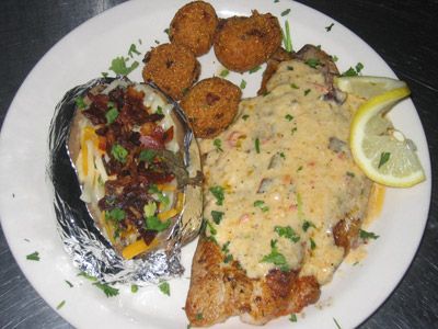 a white plate topped with meat and potatoes covered in gravy next to tater tots