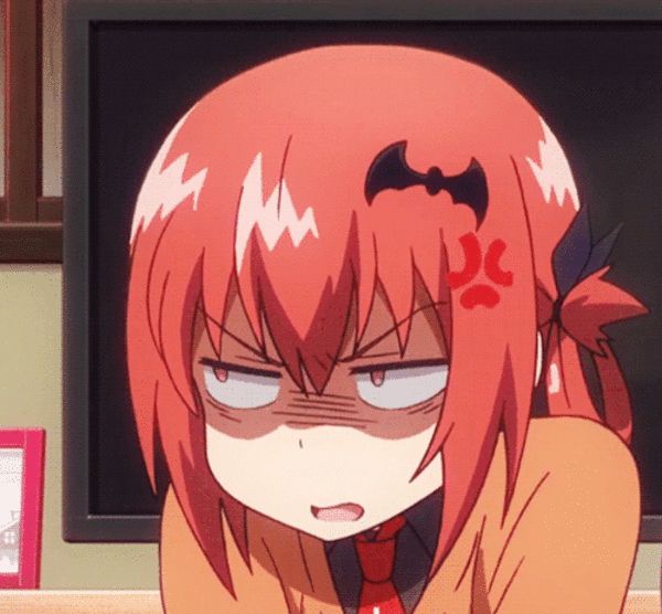 an anime character with long red hair sitting in front of a computer screen and looking at the camera