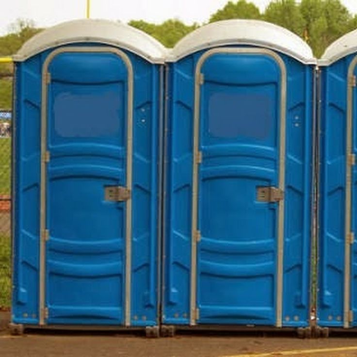 three portable toilets are lined up in a row