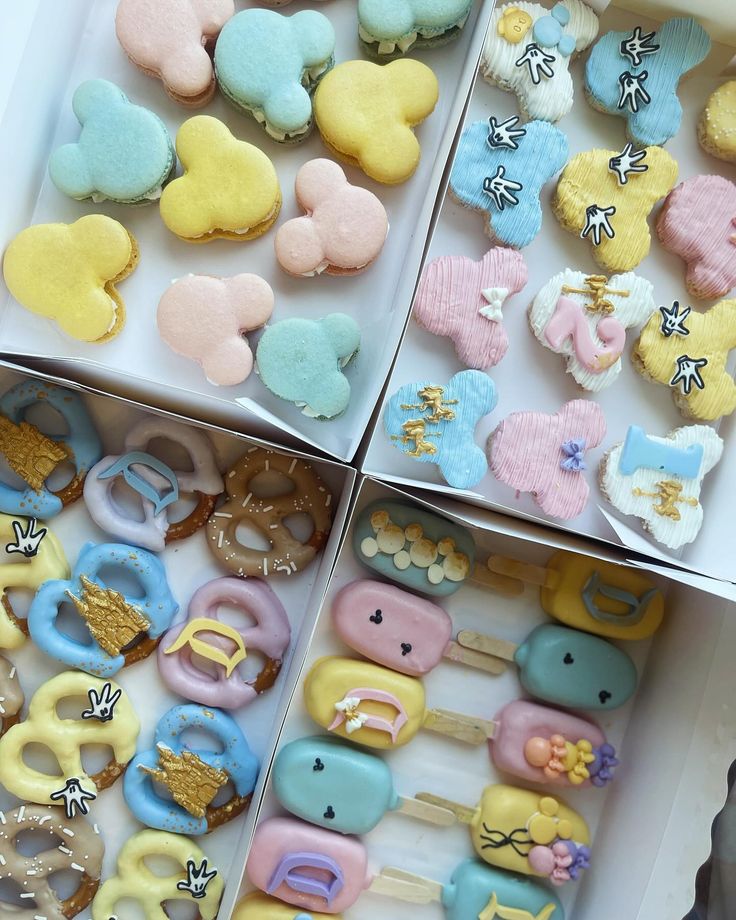 three boxes filled with different types of cookies and pastries in them, all decorated to look like cartoon characters