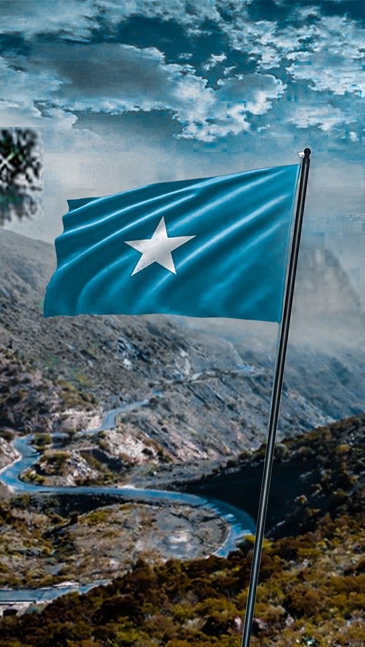 a blue and white flag flying on top of a mountain