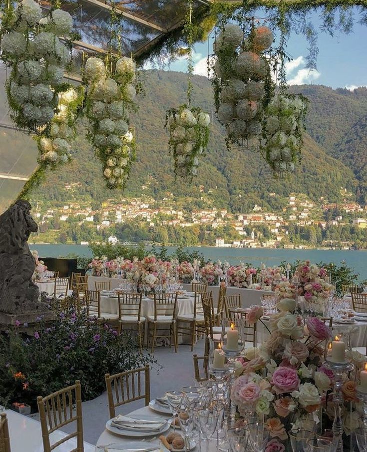 an outdoor dining area with tables and chairs set up for a formal function overlooking the water