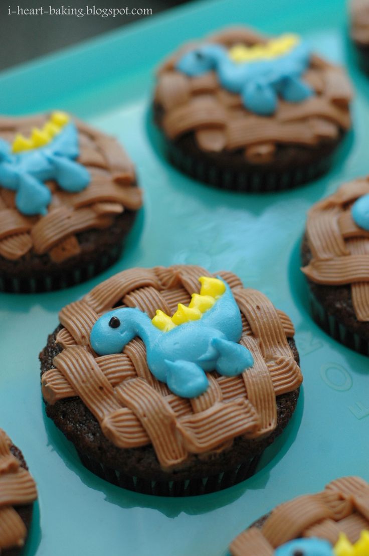 chocolate cupcakes decorated with blue and yellow icing in the shape of elephants