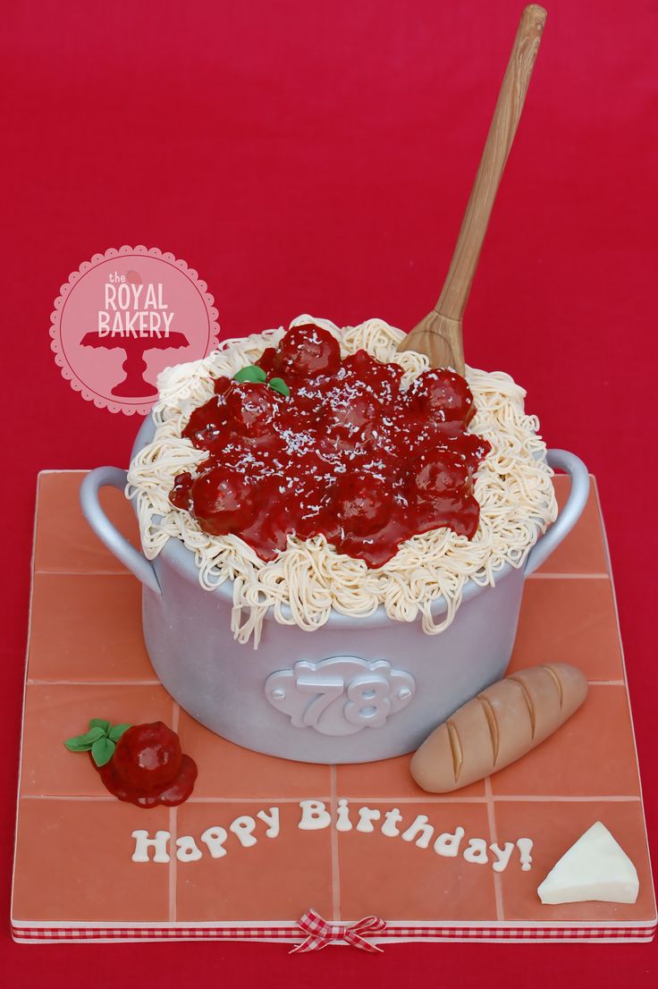 a birthday cake made to look like a bowl of spaghetti and sauce with a spoon in it