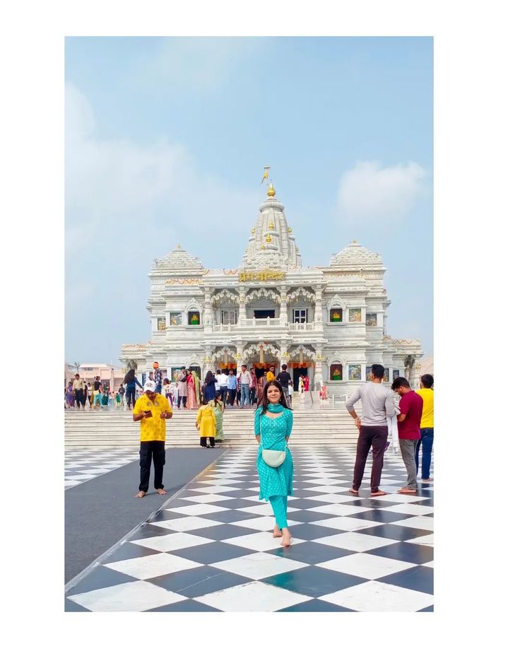 a woman standing on top of a checkered floor in front of a white building