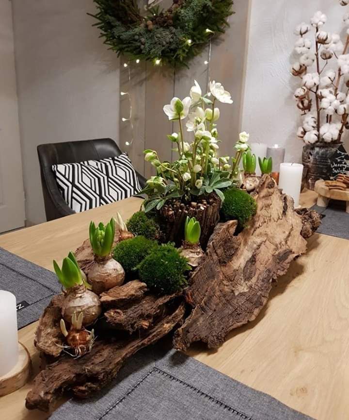 a wooden table topped with lots of plants and flowers next to a candle holder on top of a piece of wood