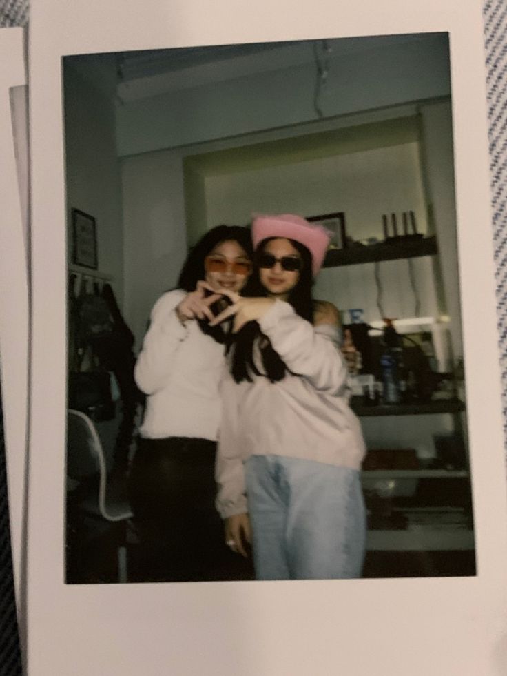 two women standing next to each other wearing pink hats