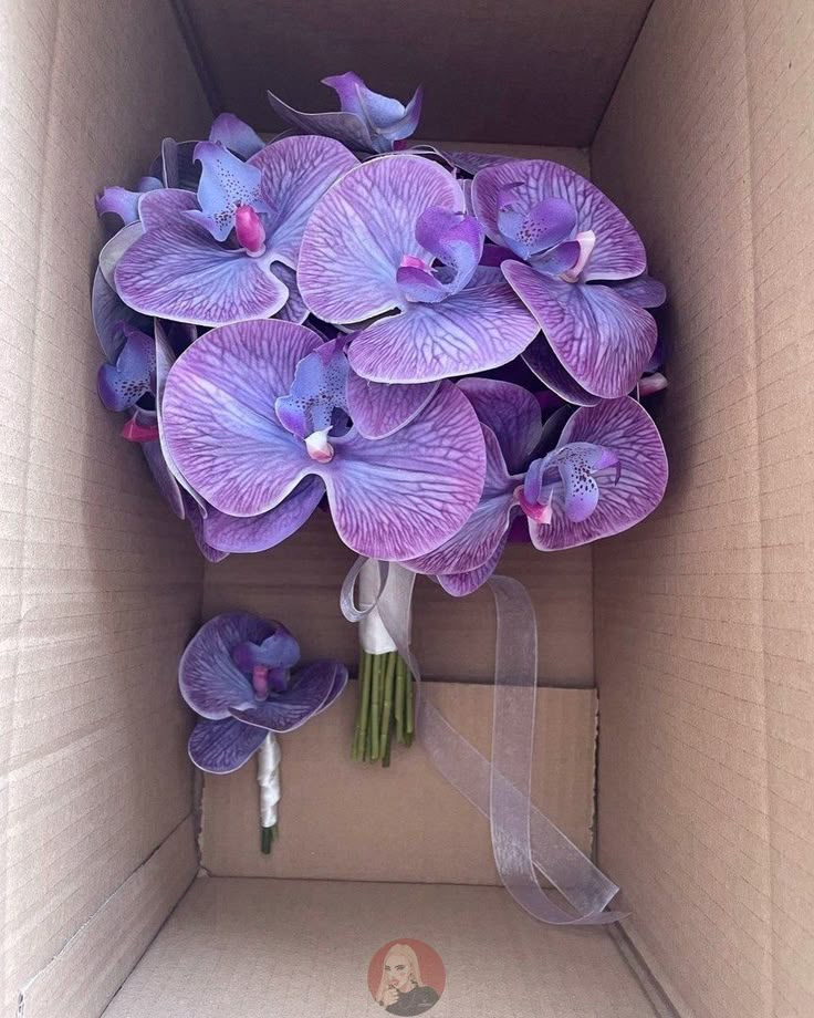 a bouquet of purple flowers in a cardboard box