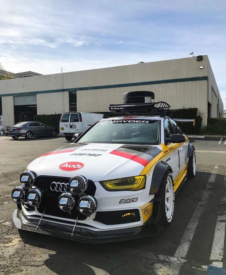 a white car with red and yellow stripes parked in a parking lot