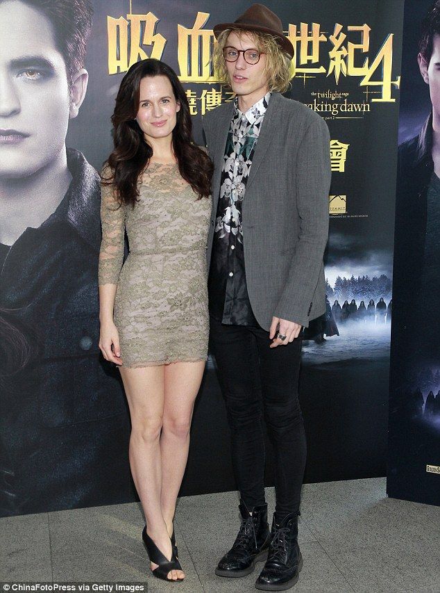 two people standing next to each other in front of a wall with harry potter on it