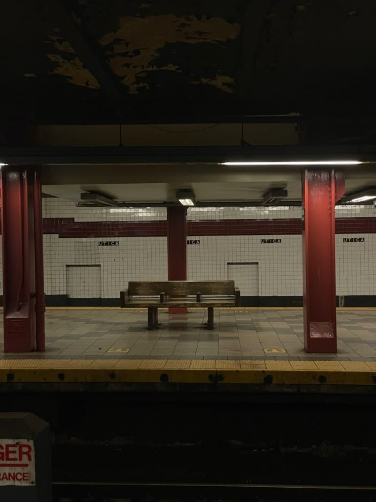 an empty bench sits in the middle of a train station