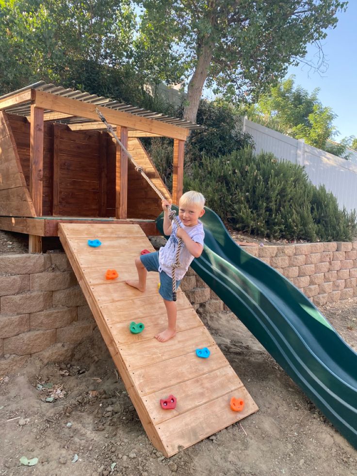 a toddler playing on a wooden slide