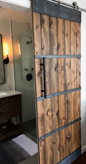 a wooden door is open in a bathroom