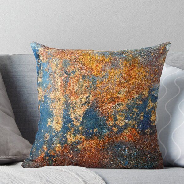 an old rusted metal surface throw pillow on a couch with white pillows and grey cushions