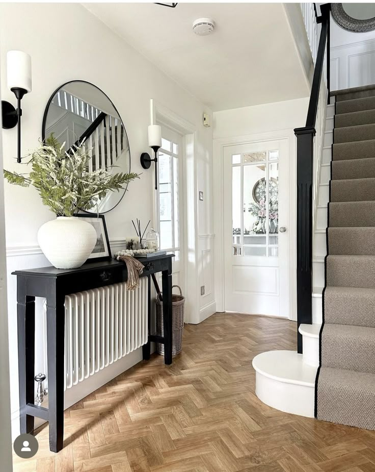 a foyer with wooden floors and white walls