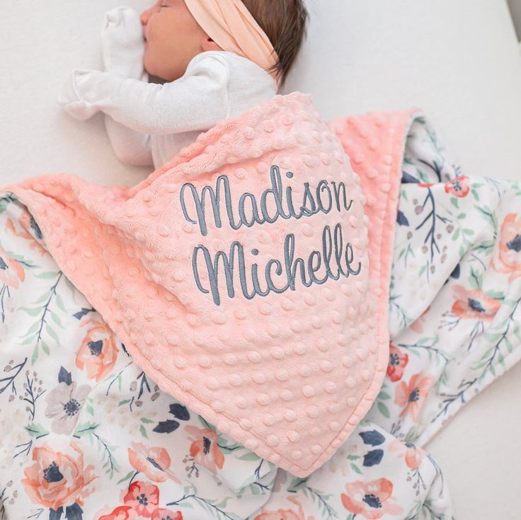 a baby wrapped in a pink blanket with the name madison michele on it