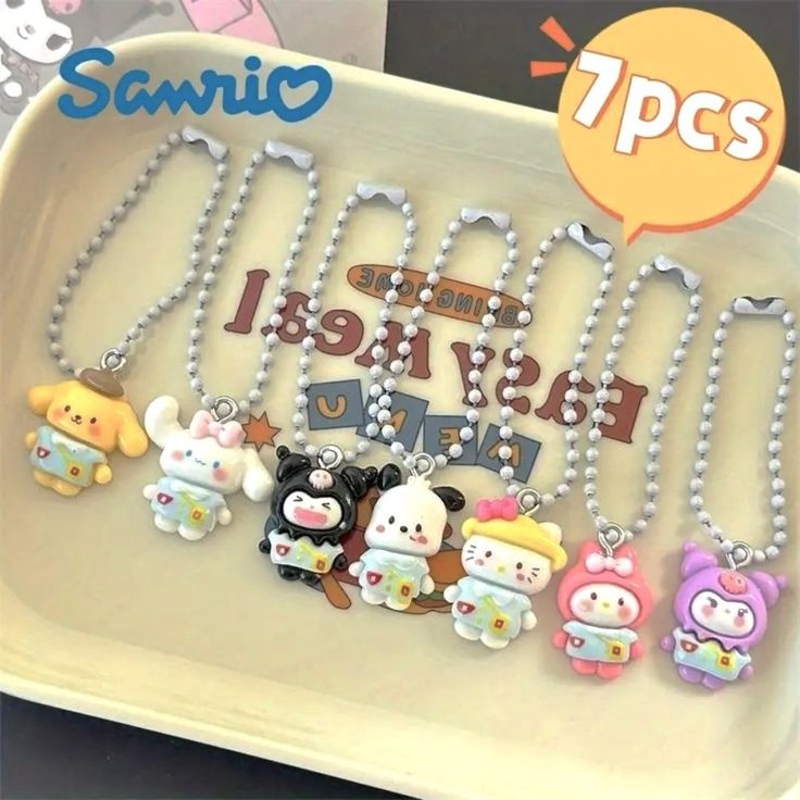 some cute little animals are on a white tray with beads and chains hanging from it