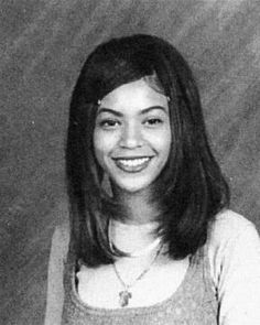 an old black and white photo of a young woman with long hair smiling at the camera