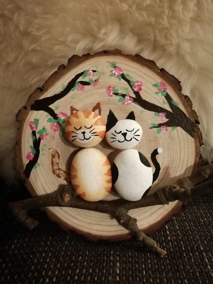 two cats sitting next to each other on top of a piece of wood in front of a tree