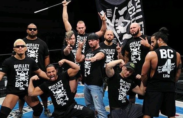 a group of men standing next to each other on top of a blue wrestling ring