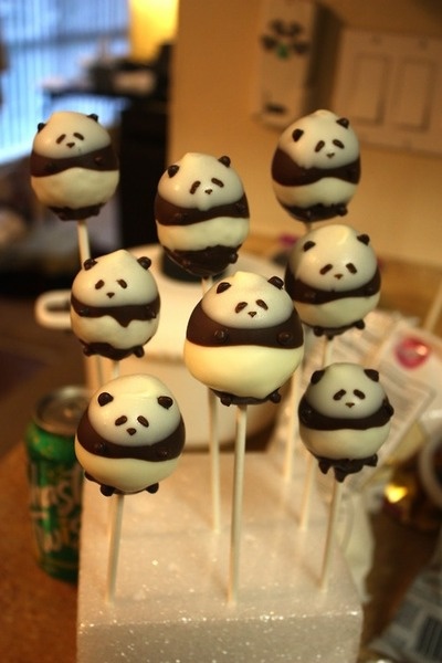 there are many panda cake pops on the stick with white frosting and chocolate toppings