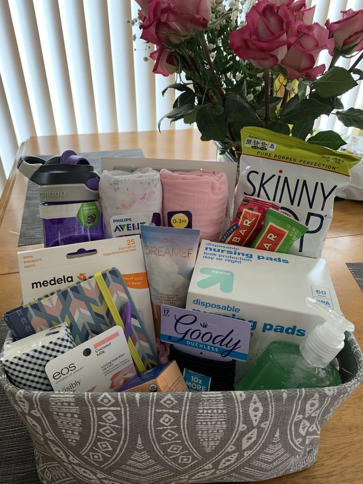 a basket filled with personal care items on top of a wooden table next to a pink rose