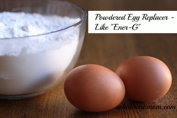 two eggs sitting next to each other in front of a bowl filled with egg replacer