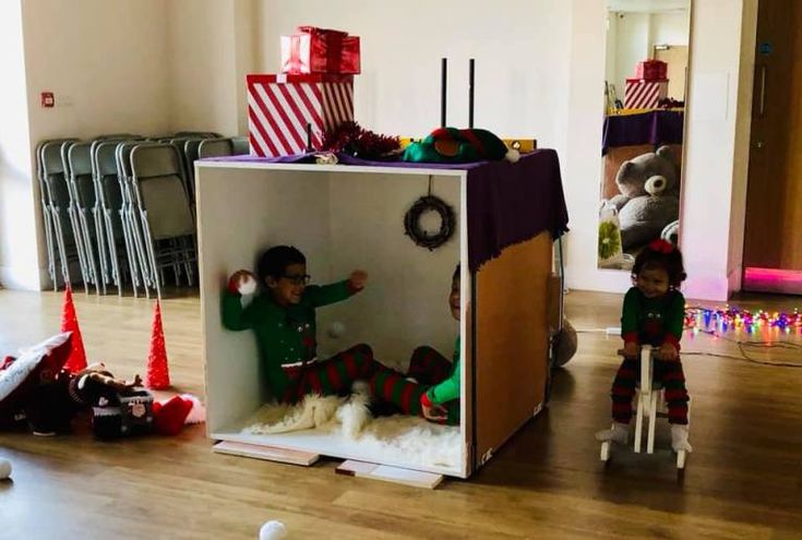 two children playing in a play house with christmas decorations on the walls and around them