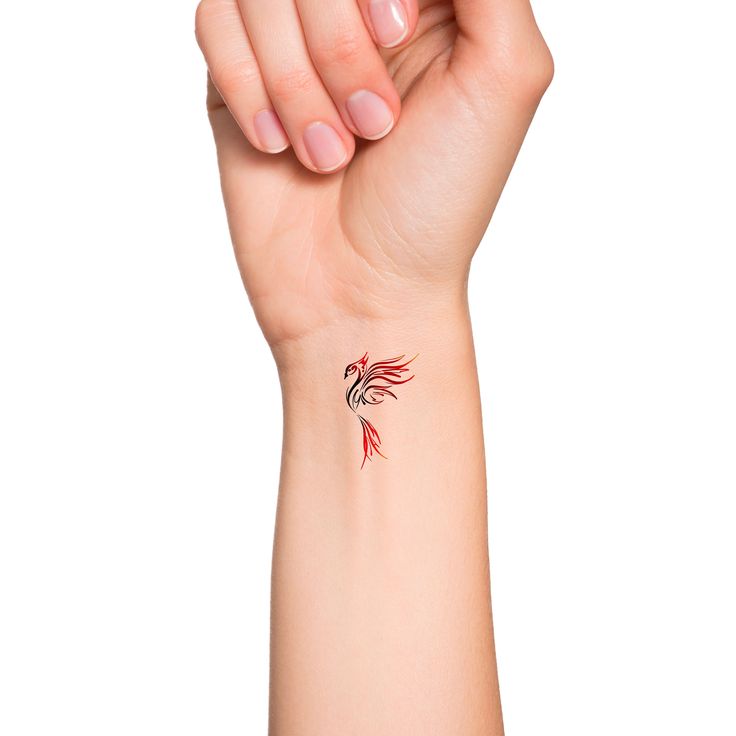 a woman's arm with a red and black tattoo design on the left wrist