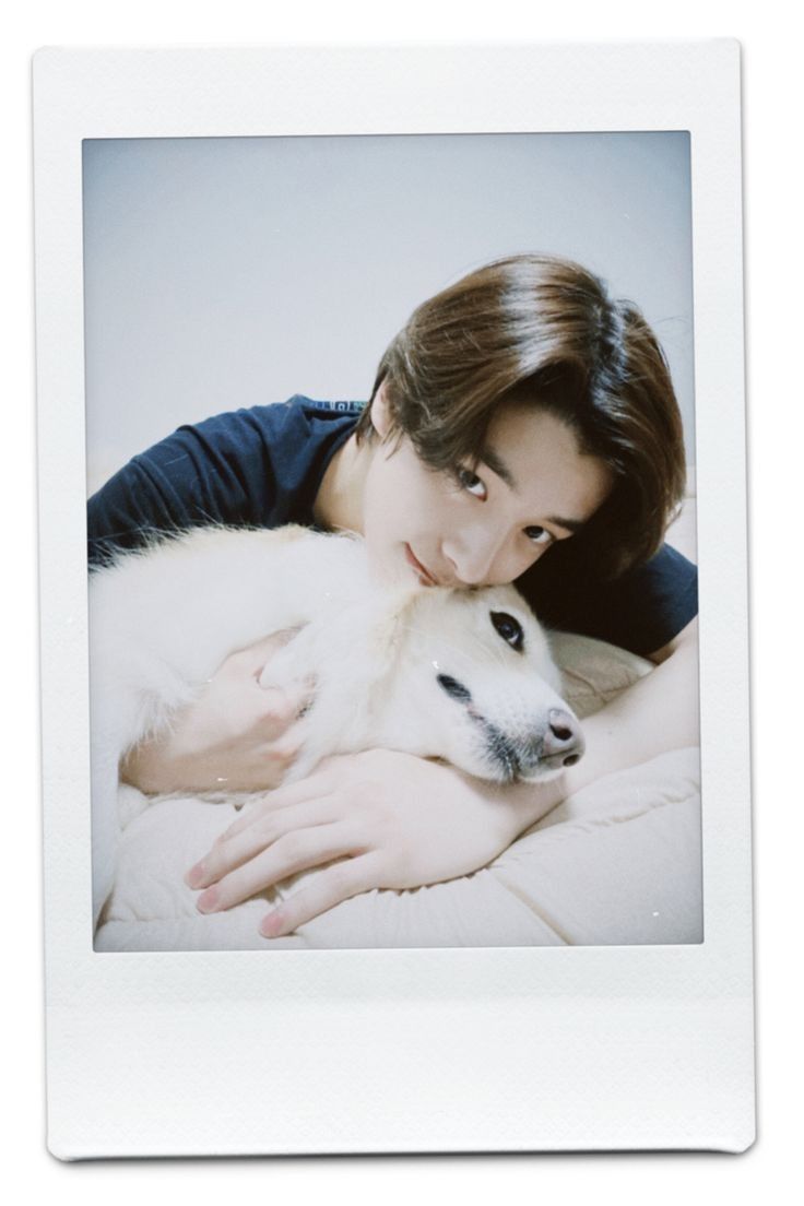 a woman cuddles with her dog on the bed in front of her is a polaroid frame