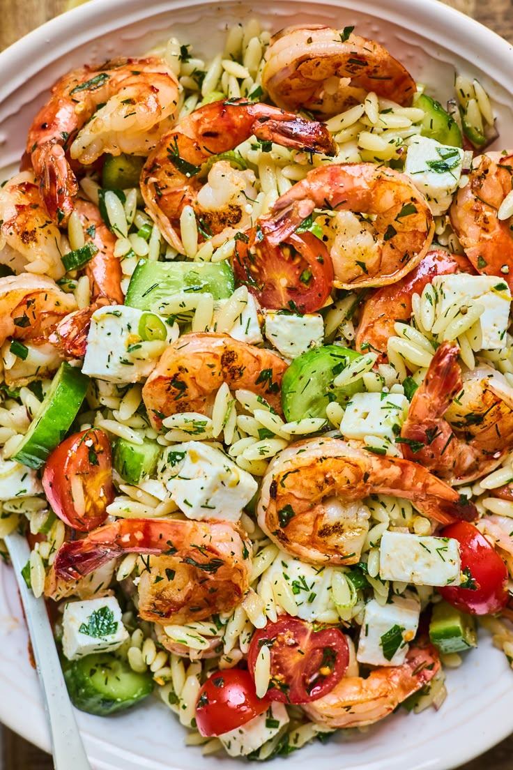 pasta salad with shrimp and vegetables in a white bowl