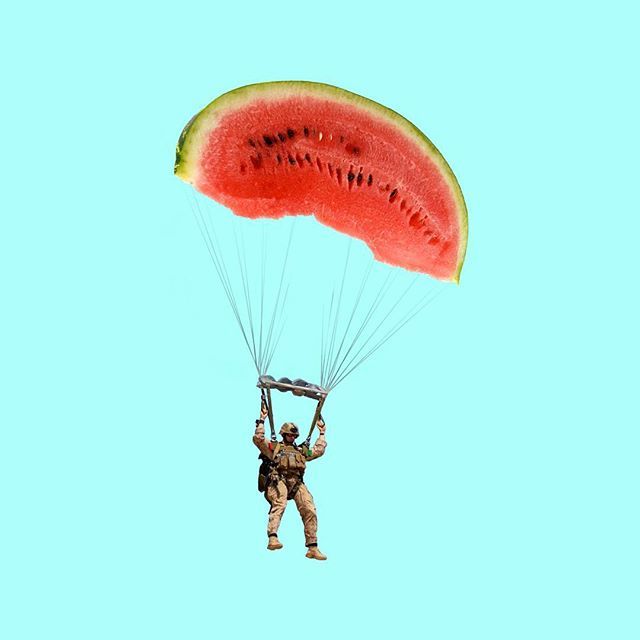 a watermelon slice being lifted by a man in the air with a parachute