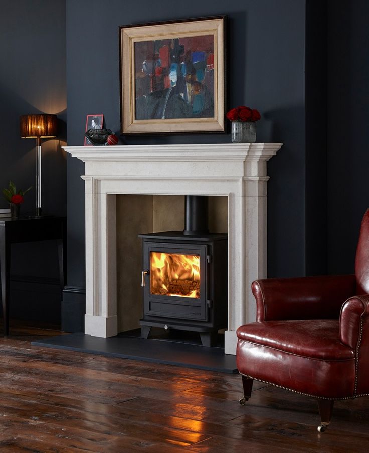 a living room with a fire place in the middle and a chair next to it