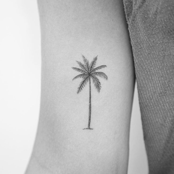 a small palm tree tattoo on the left thigh