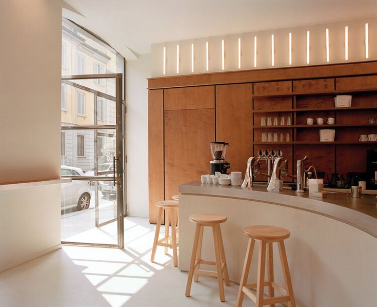 a kitchen filled with lots of counter top space and wooden stools next to it