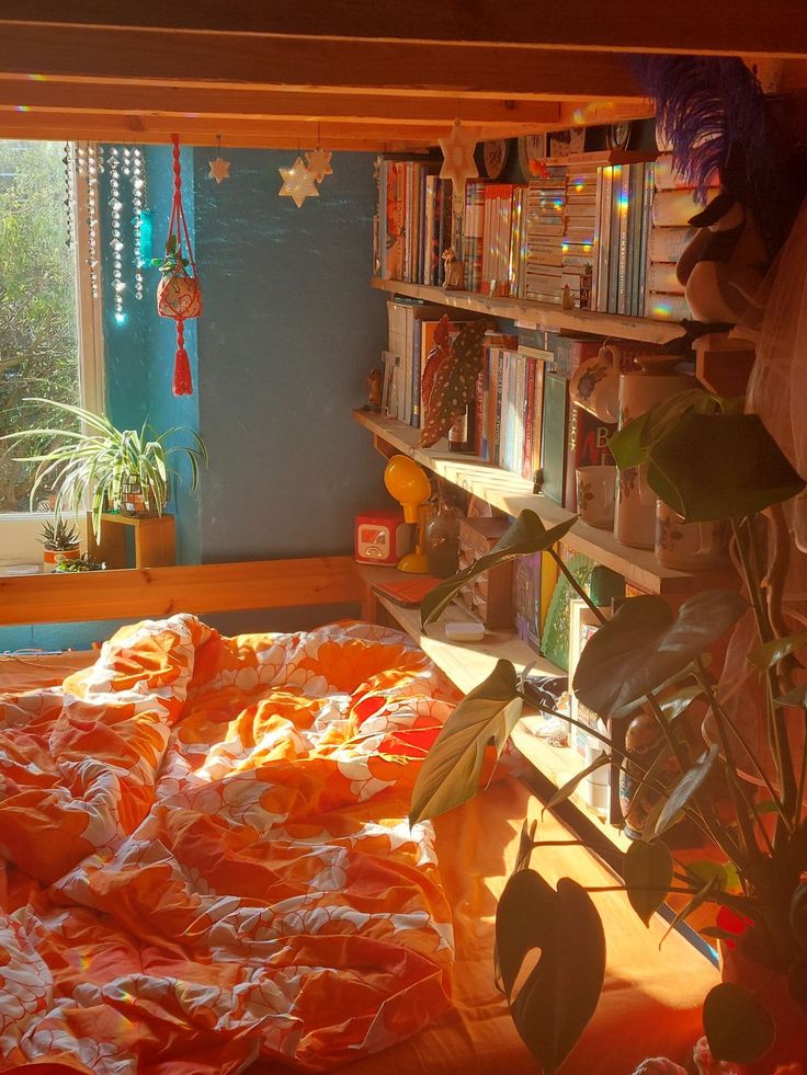 an orange bed in a room with lots of bookshelves and plants on the shelves