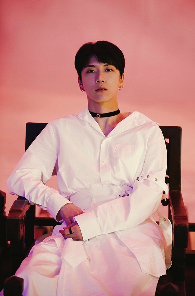 a man sitting in a chair wearing a white outfit