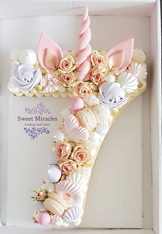 a cake shaped like the number seven with flowers and seashells on it in a box