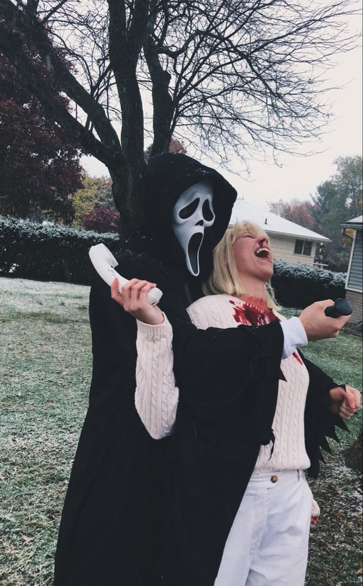 two people dressed up in costumes and holding remotes