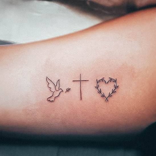 a cross with two doves and a heart tattoo on the left side of the arm